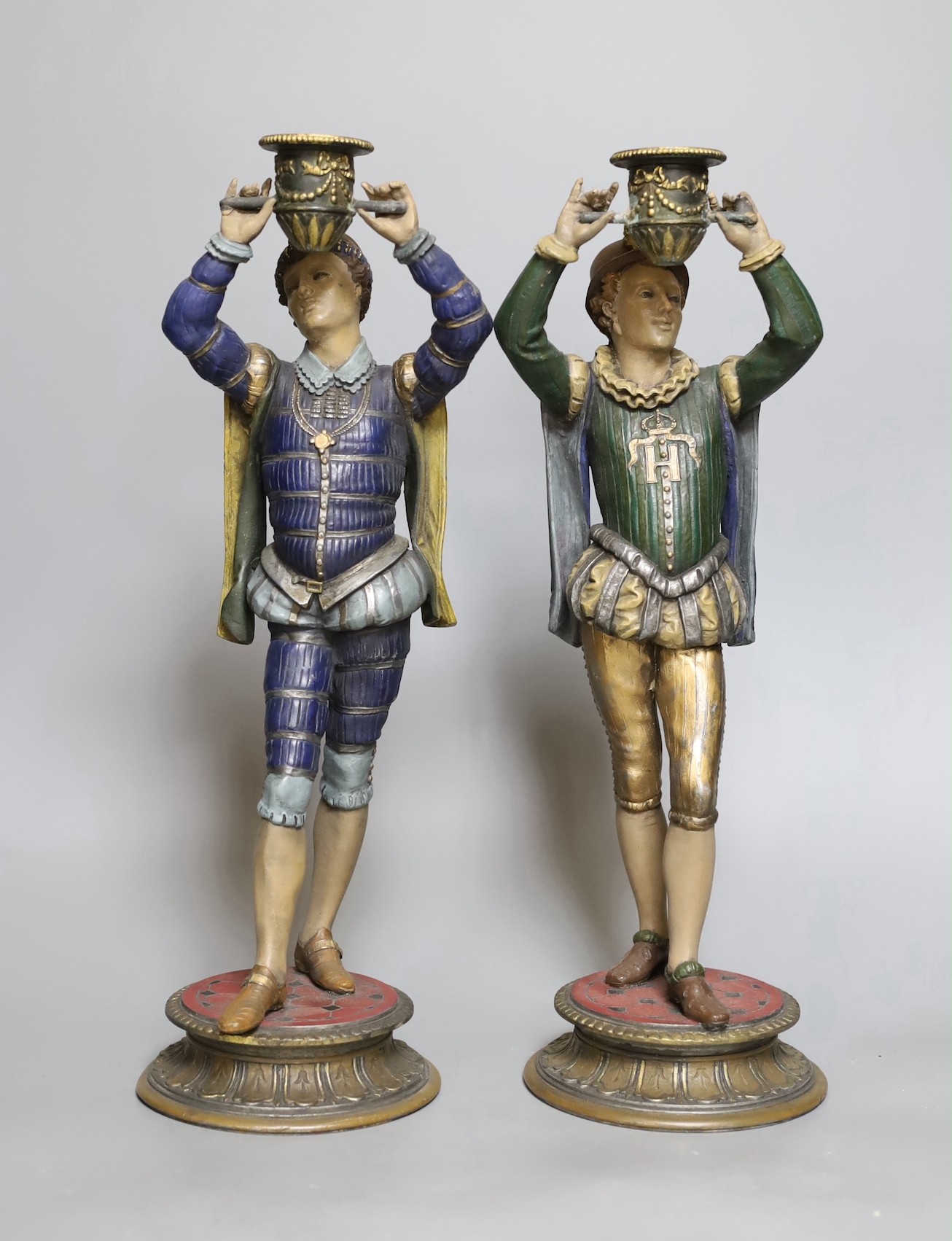 A pair of painted spelter figural candlesticks, 35.5 cms high